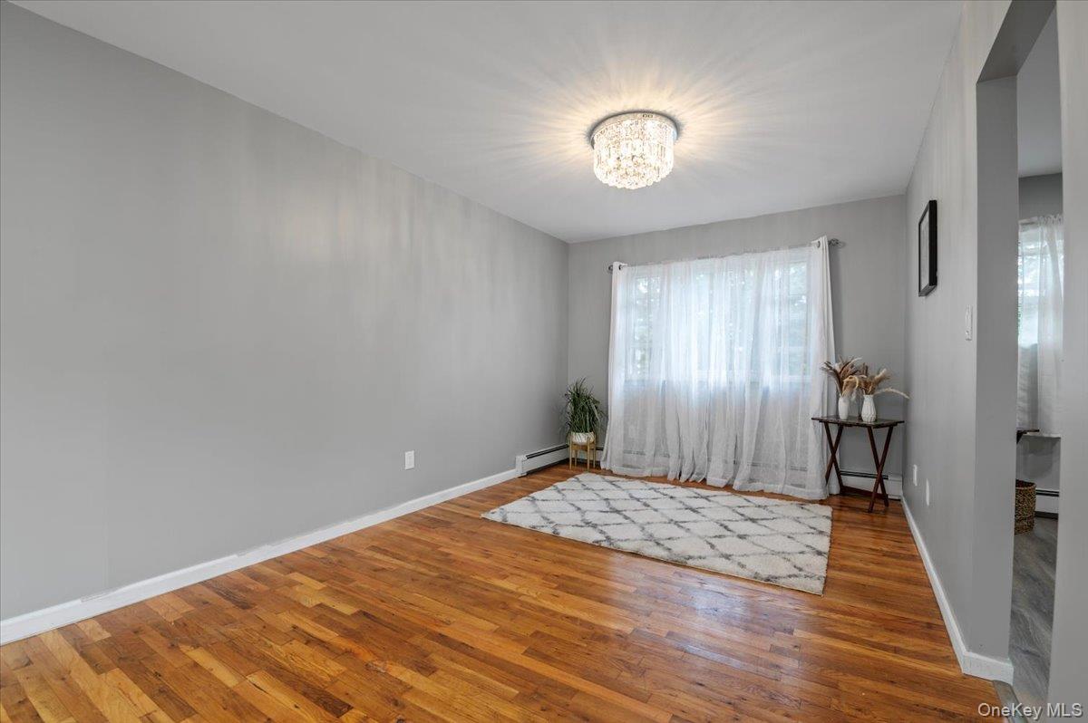 7 Bennett Court Copiague, NY 11726 - Photo 6 of 22 a view of a room with wooden floor and a chandelier