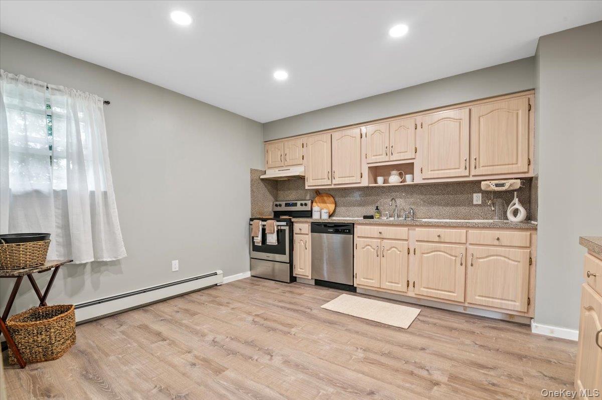 7 Bennett Court Copiague, NY 11726 - Photo 8 of 22 a kitchen with granite countertop white cabinets and appliances