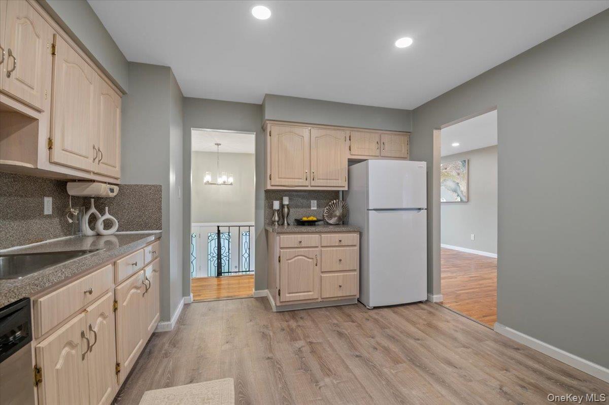 7 Bennett Court Copiague, NY 11726 - Photo 10 of 22 a kitchen with a refrigerator a stove top oven and cabinets