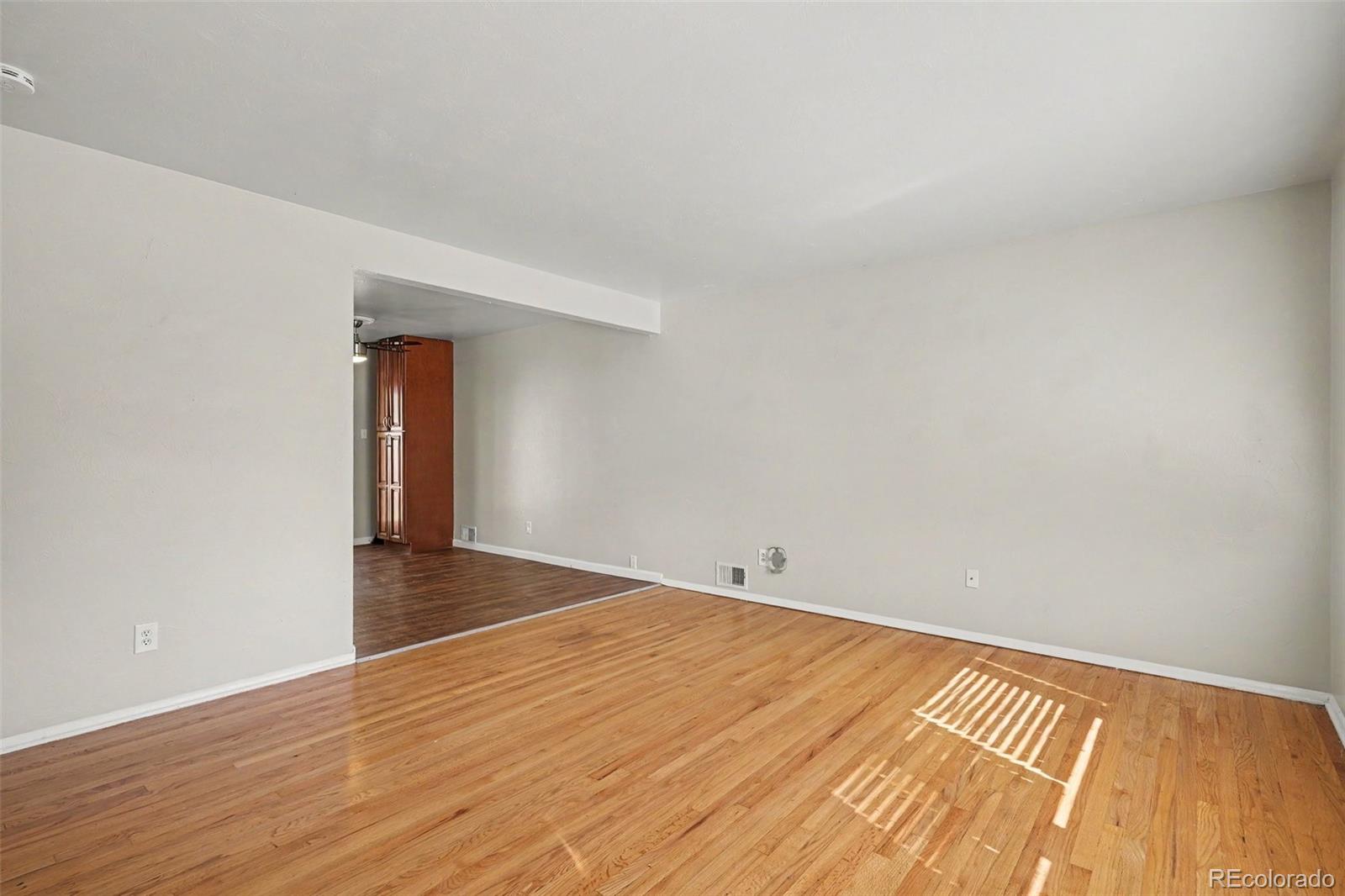 3217 South Stuart Street Denver, CO 80236 - Photo 7 of 29 a view of an empty room and wooden floor