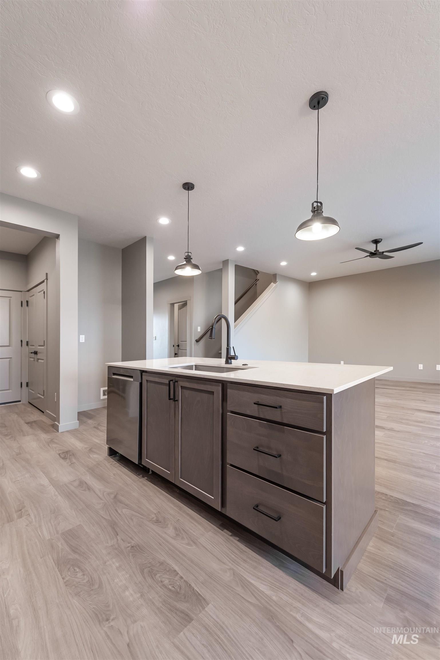 360 South Bumper Way Boise, ID 83716 - Photo 34 of 34 Kitchen with hanging light fixtures, an island with sink, open floor plan, light wood-style floors, and recessed lighting