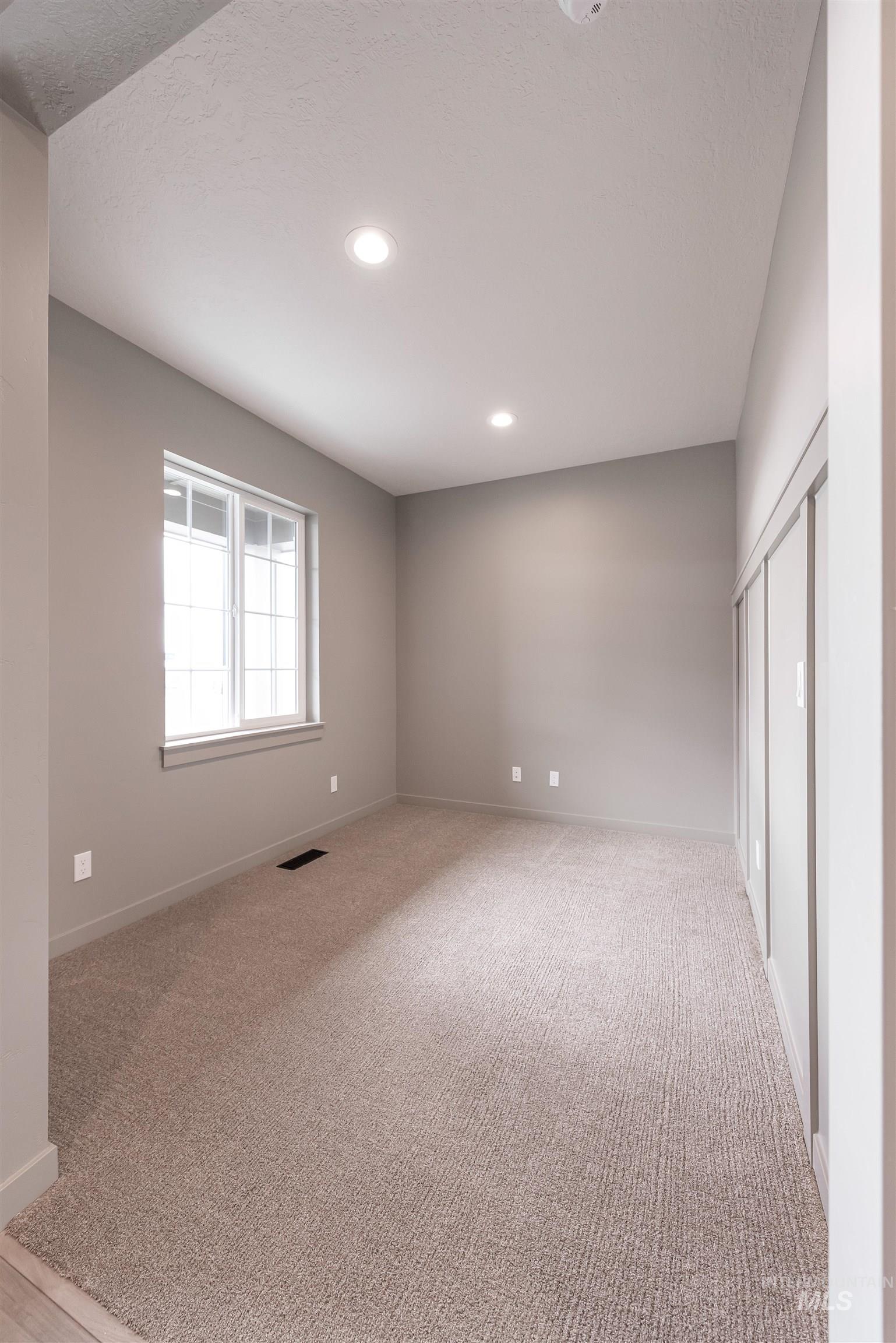 360 South Bumper Way Boise, ID 83716 - Photo 11 of 34 Empty room with light carpet, recessed lighting, and a textured ceiling