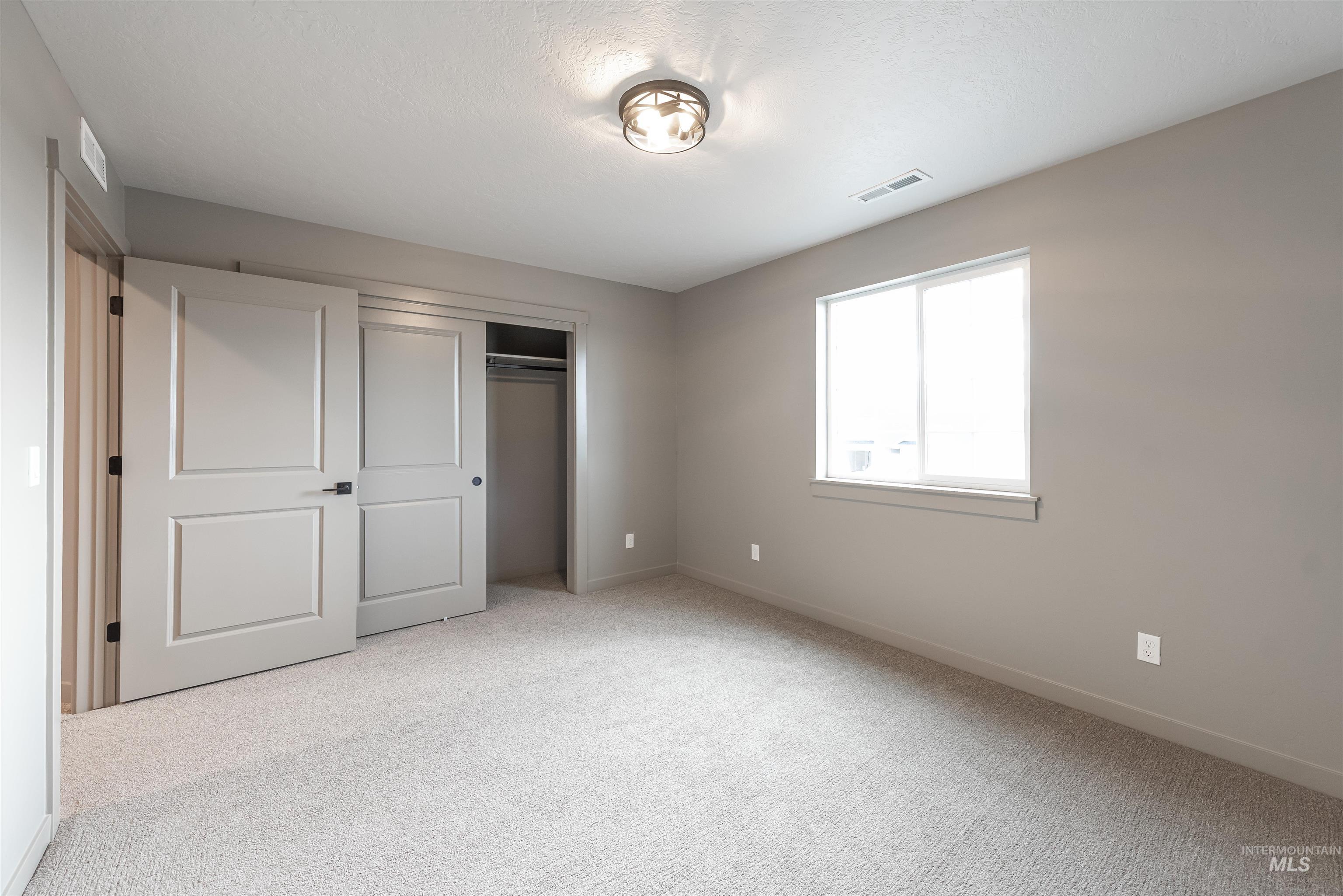 360 South Bumper Way Boise, ID 83716 - Photo 23 of 34 Unfurnished bedroom with light carpet and a closet