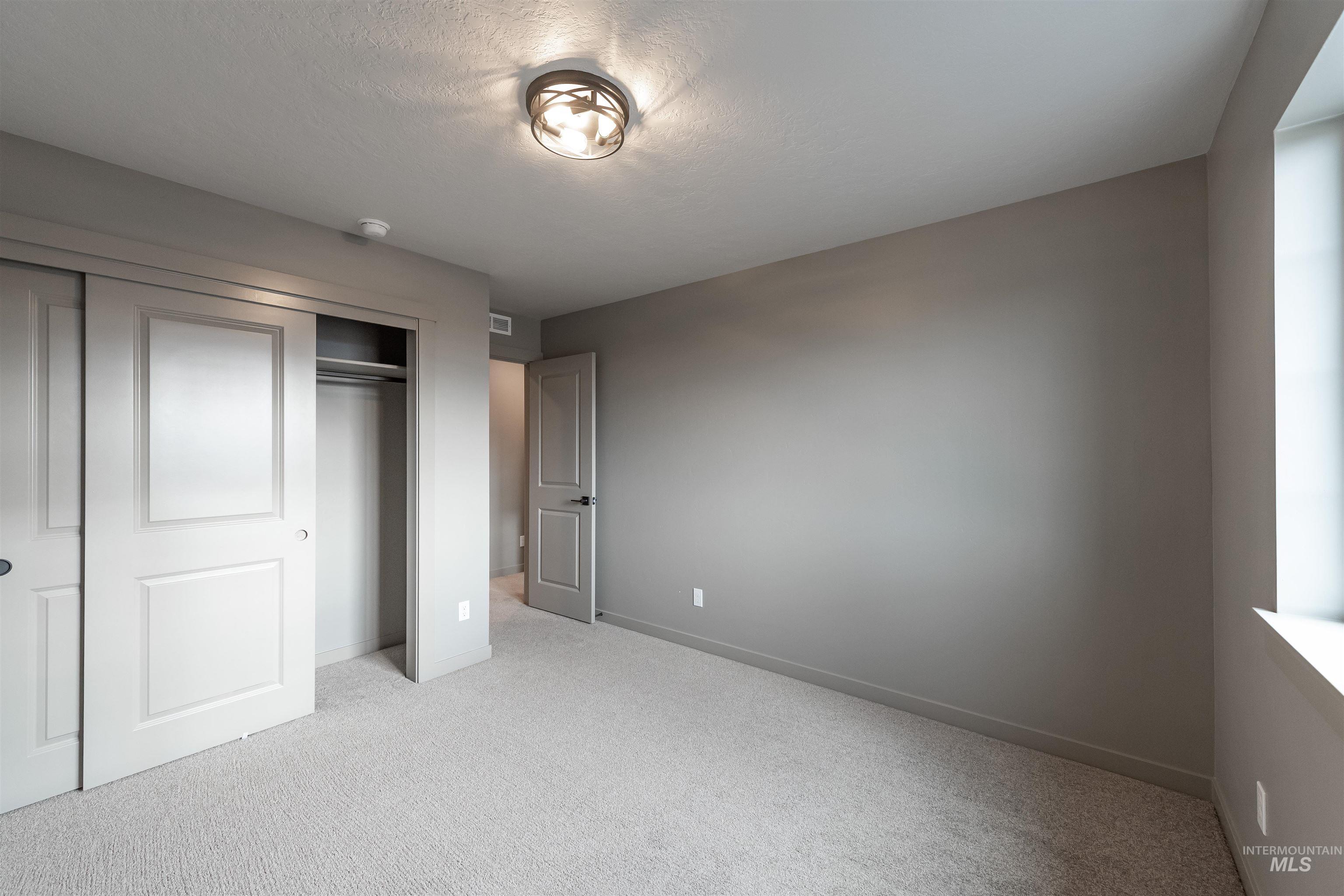 360 South Bumper Way Boise, ID 83716 - Photo 25 of 34 Unfurnished bedroom featuring light colored carpet and a closet
