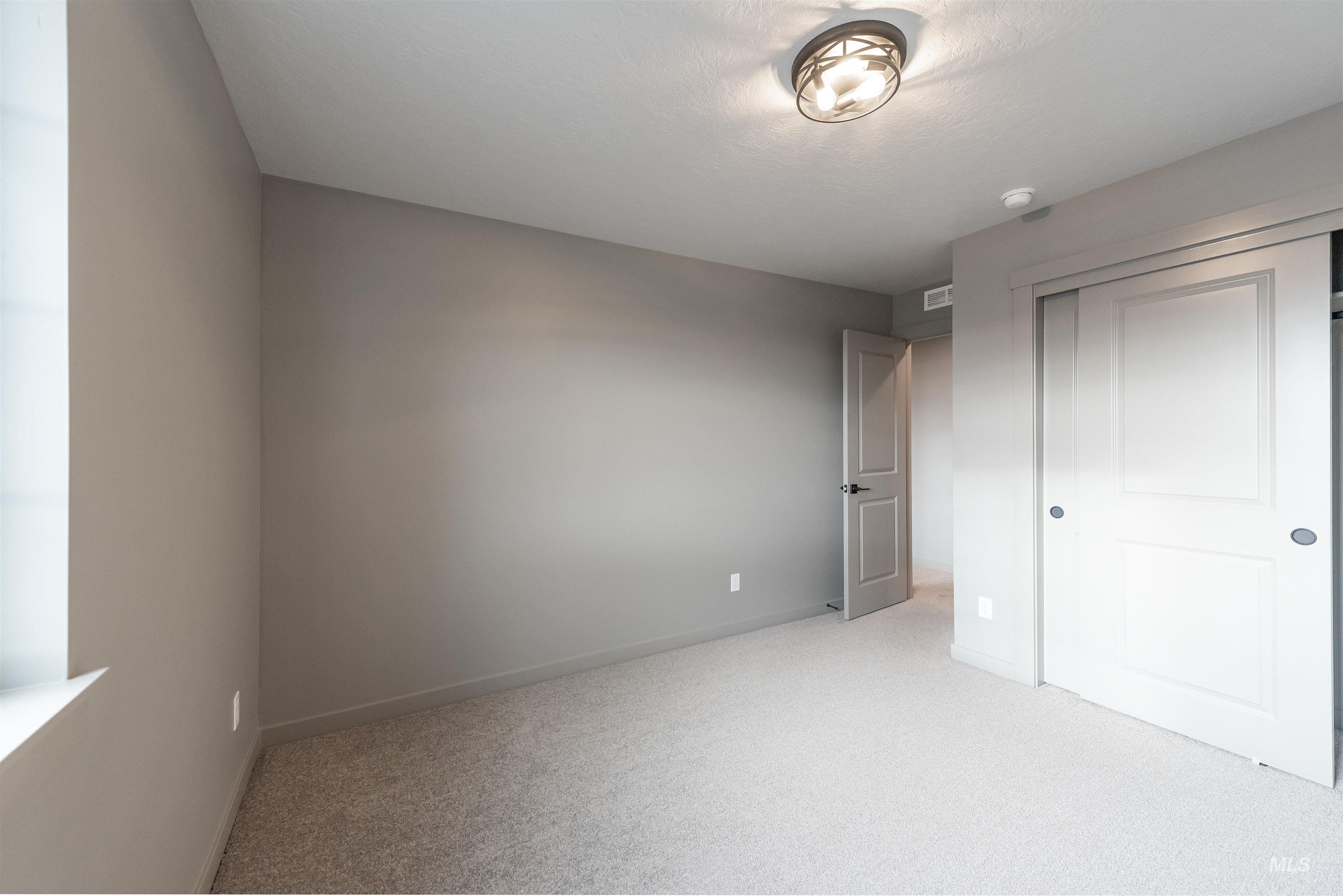 360 South Bumper Way Boise, ID 83716 - Photo 28 of 34 Unfurnished bedroom with light colored carpet and a closet