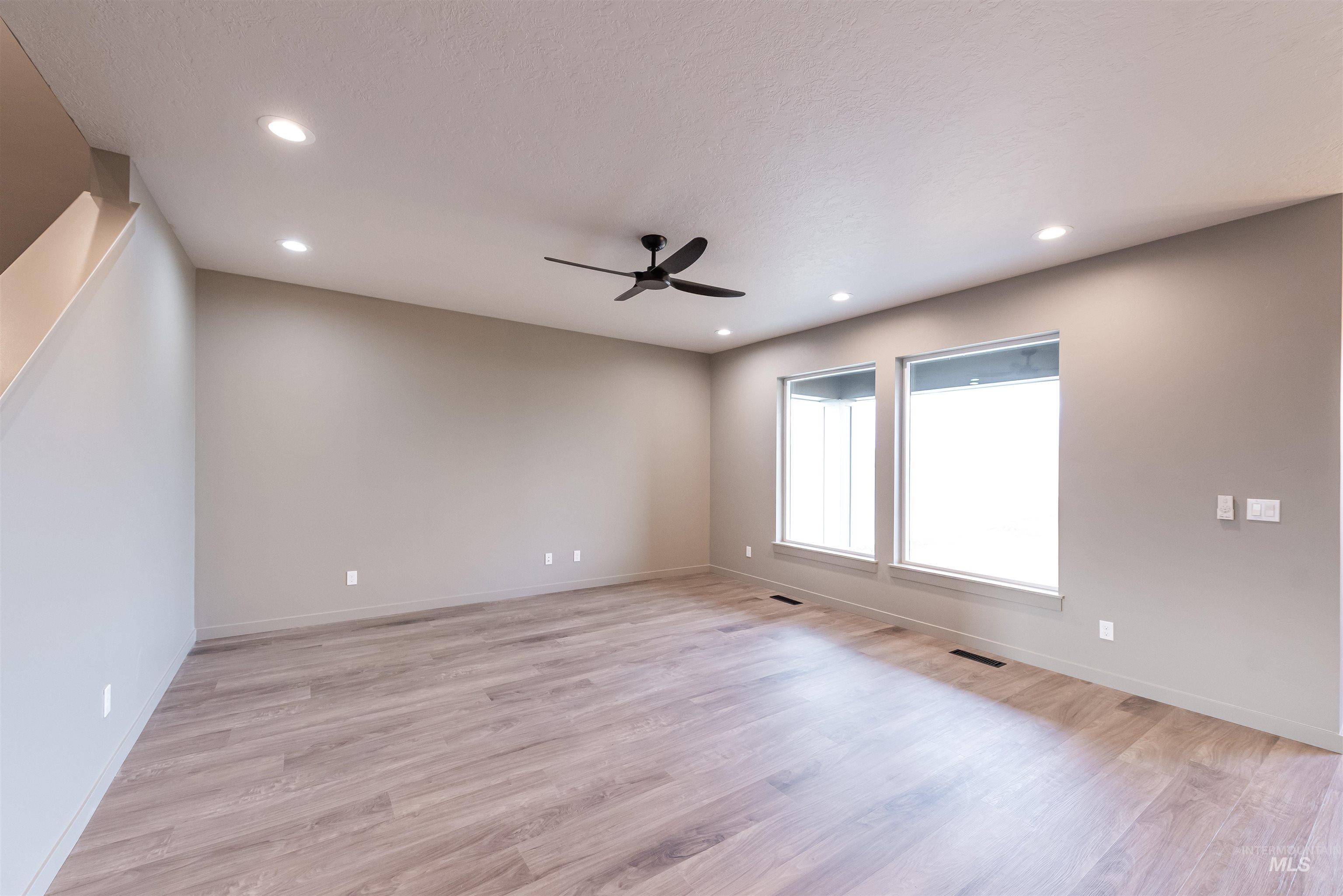 360 South Bumper Way Boise, ID 83716 - Photo 3 of 34 Empty room with light wood-style floors, recessed lighting, and a ceiling fan