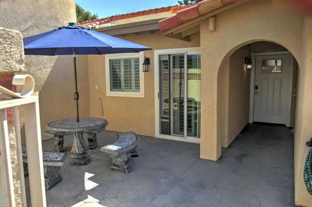a view of a patio with table and chairs under an umbrella