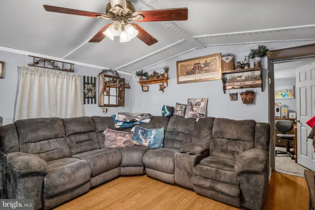 a living room with furniture and a ceiling fan
