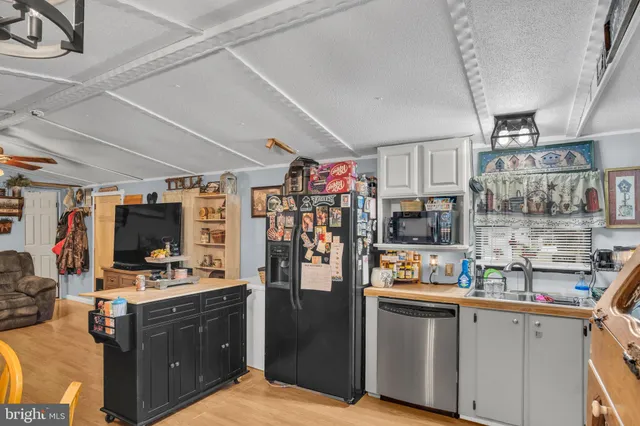 a kitchen with stainless steel appliances kitchen island granite countertop a refrigerator and cabinets