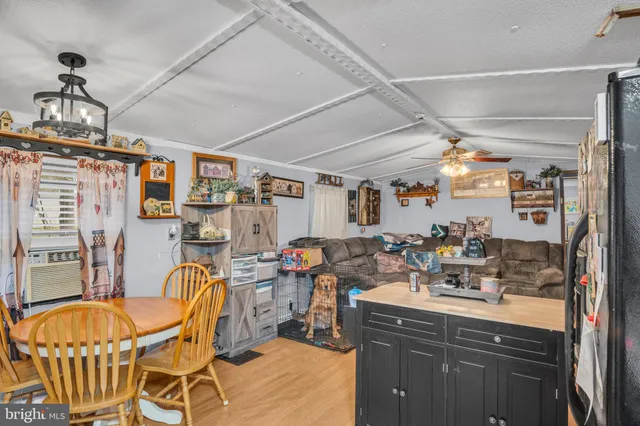a view of a dining room with furniture a chandelier and kitchen view