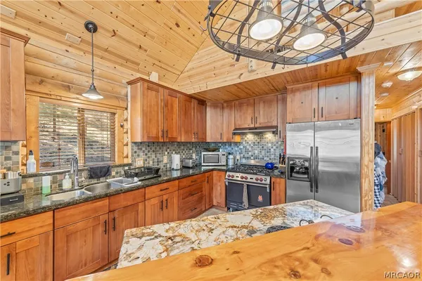 a kitchen with stainless steel appliances kitchen island granite countertop a sink and cabinets