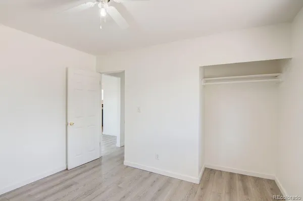 an empty room with wooden floor and closet