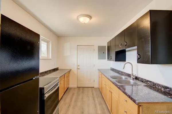 a kitchen with granite countertop a sink a counter top space stainless steel appliances and cabinets