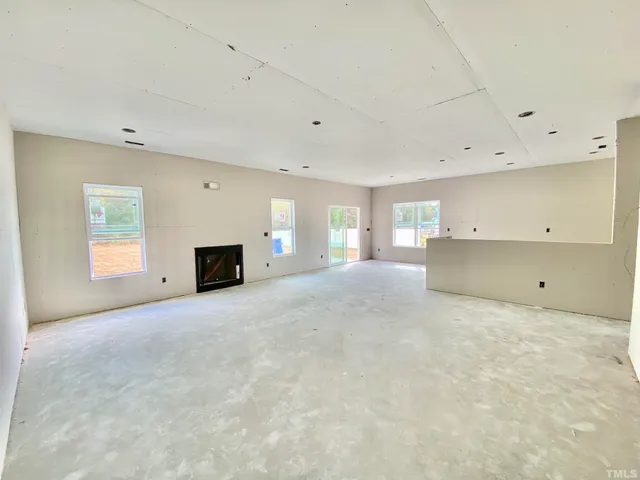 a view of empty room with a fireplace and window
