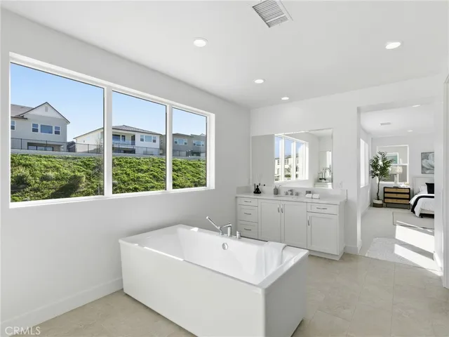 a bathroom with a tub sink and mirror