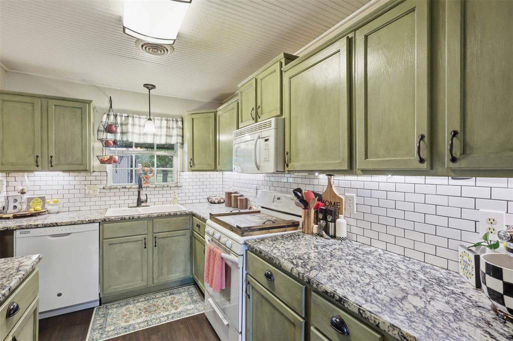 308 West 1st Street Springtown, TX 76082 - Photo 12 of 39 Kitchen featuring green cabinetry, granite countertops, white subway tile backsplash, and a white beadboard ceiling