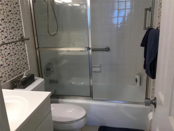 a bathroom with a shower a toilet and sink