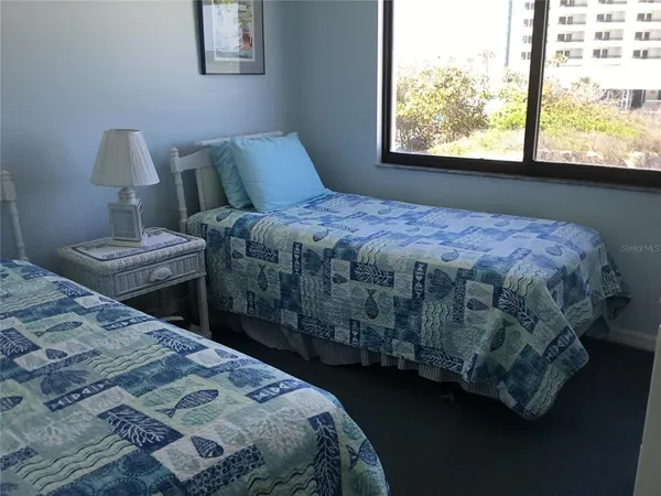 a bedroom with a bed wooden floor and window