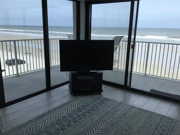 a living room with a large window and a flat screen tv