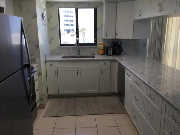 a kitchen with a refrigerator sink and cabinets