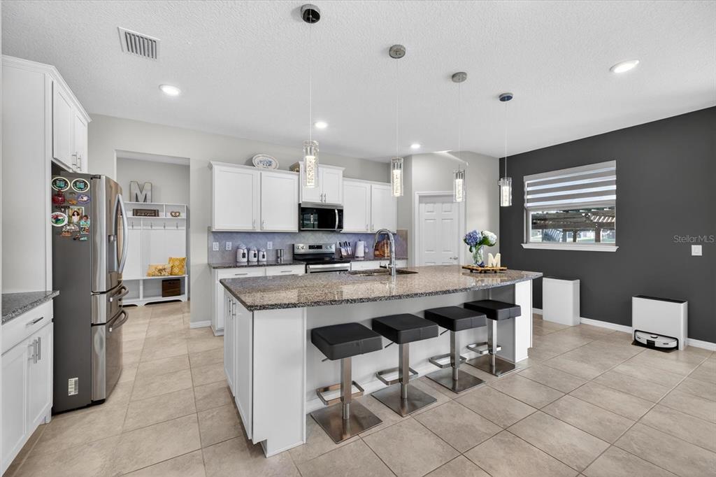 12740 Palapa Loop Spring Hill, FL 34610 - Photo 26 of 68 a kitchen with stainless steel appliances kitchen island granite countertop a sink and a refrigerator