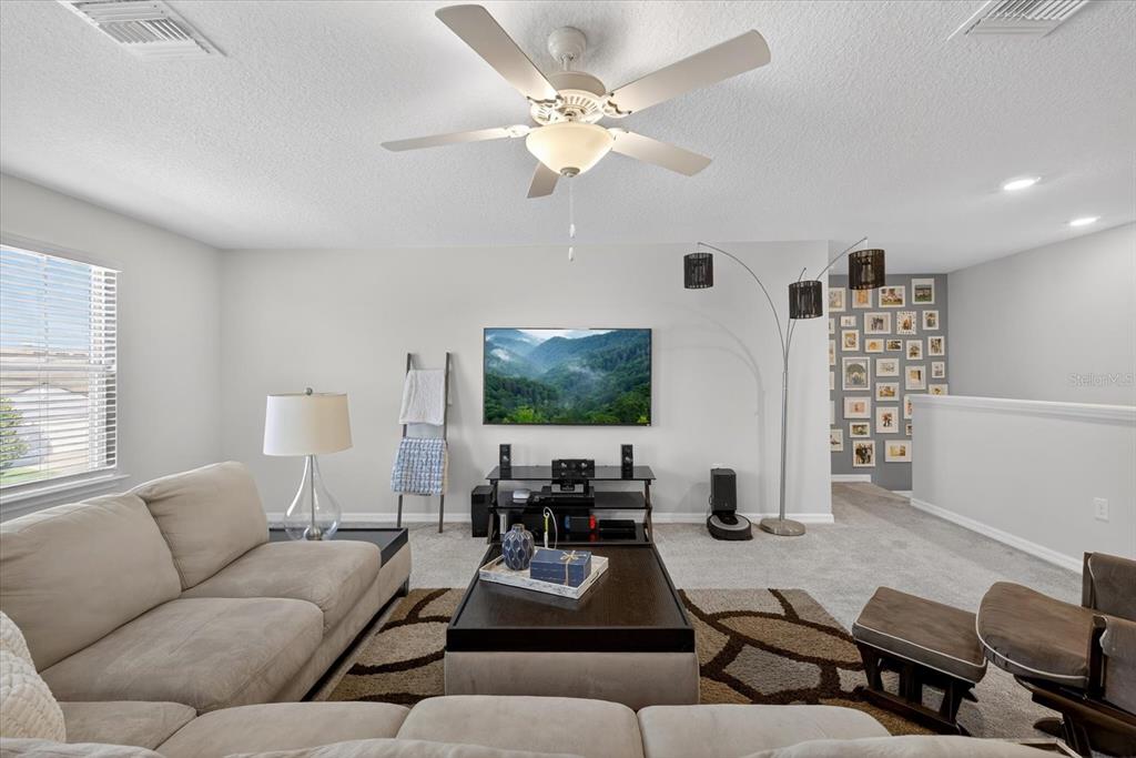 12740 Palapa Loop Spring Hill, FL 34610 - Photo 31 of 68 a living room with furniture a flat screen tv and a window