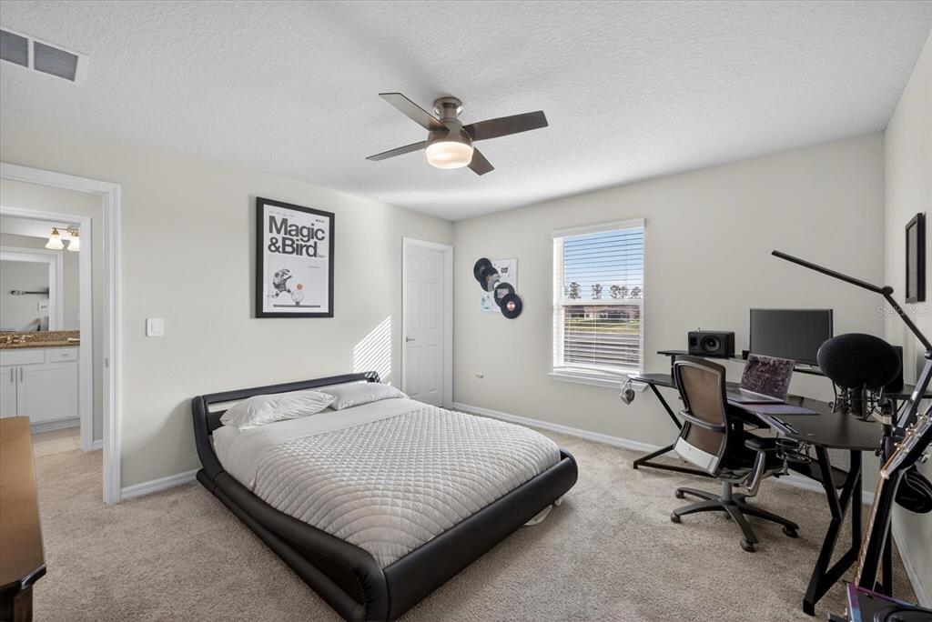 12740 Palapa Loop Spring Hill, FL 34610 - Photo 37 of 68 a bedroom with a bed a desk and chair