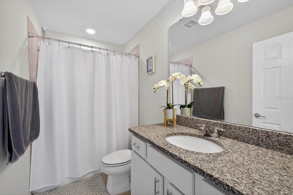 12740 Palapa Loop Spring Hill, FL 34610 - Photo 47 of 68 a bathroom with a granite countertop sink toilet and a mirror