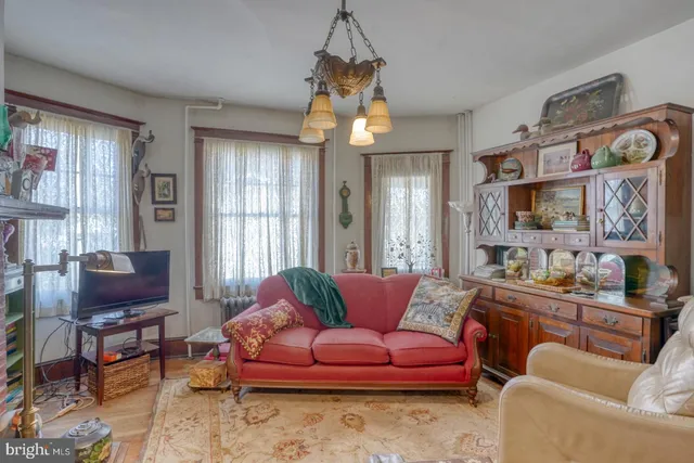 a kitchen with stainless steel appliances granite countertop a stove a refrigerator a sink a dining table and chairs with wooden floor