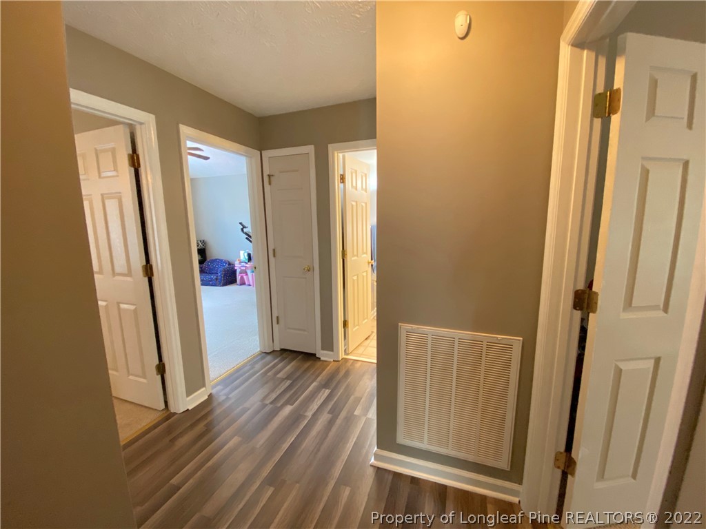 271 Stone Cross Drive Spring Lake, NC 28390 - Photo 19 of 38 a view of a hallway with wooden floor and closet area