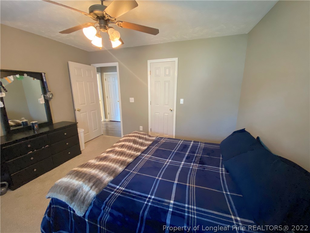 271 Stone Cross Drive Spring Lake, NC 28390 - Photo 21 of 38 a bedroom with a bed and a flat tv screen on the dresser