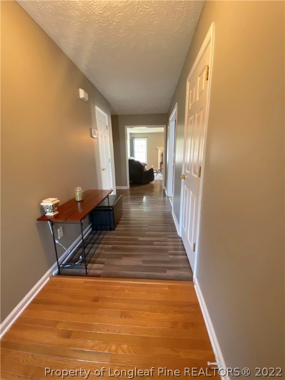 271 Stone Cross Drive Spring Lake, NC 28390 - Photo 6 of 38 a view of a hallway with wooden floor and a potted plant