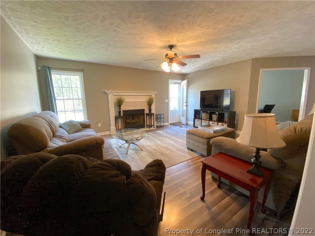 271 Stone Cross Drive Spring Lake, NC 28390 - Photo 7 of 38 a living room with furniture a fireplace and a flat screen tv