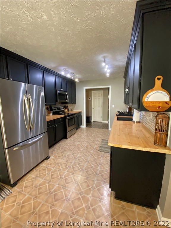 271 Stone Cross Drive Spring Lake, NC 28390 - Photo 10 of 38 a kitchen with stainless steel appliances granite countertop a refrigerator a stove and a sink