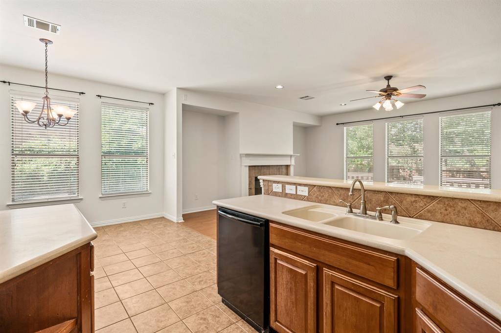 808 Briar Ridge Drive Keller, TX 76248 - Photo 16 of 40 Kitchen featuring a double basin sink, light-toned countertops, wood cabinetry, and a tile backsplash