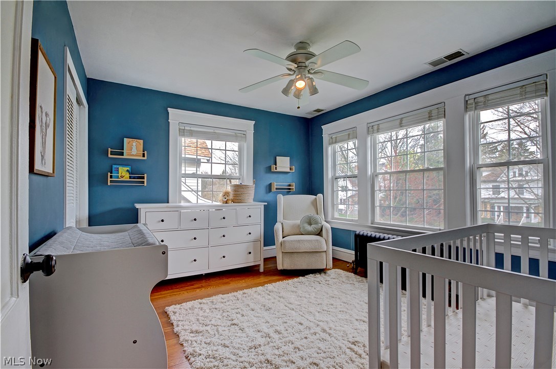 3054 Somerton Road Cleveland, OH 44118 - Photo 27 of 40 Bedroom with light hardwood / wood-style flooring, ceiling fan, and a crib
