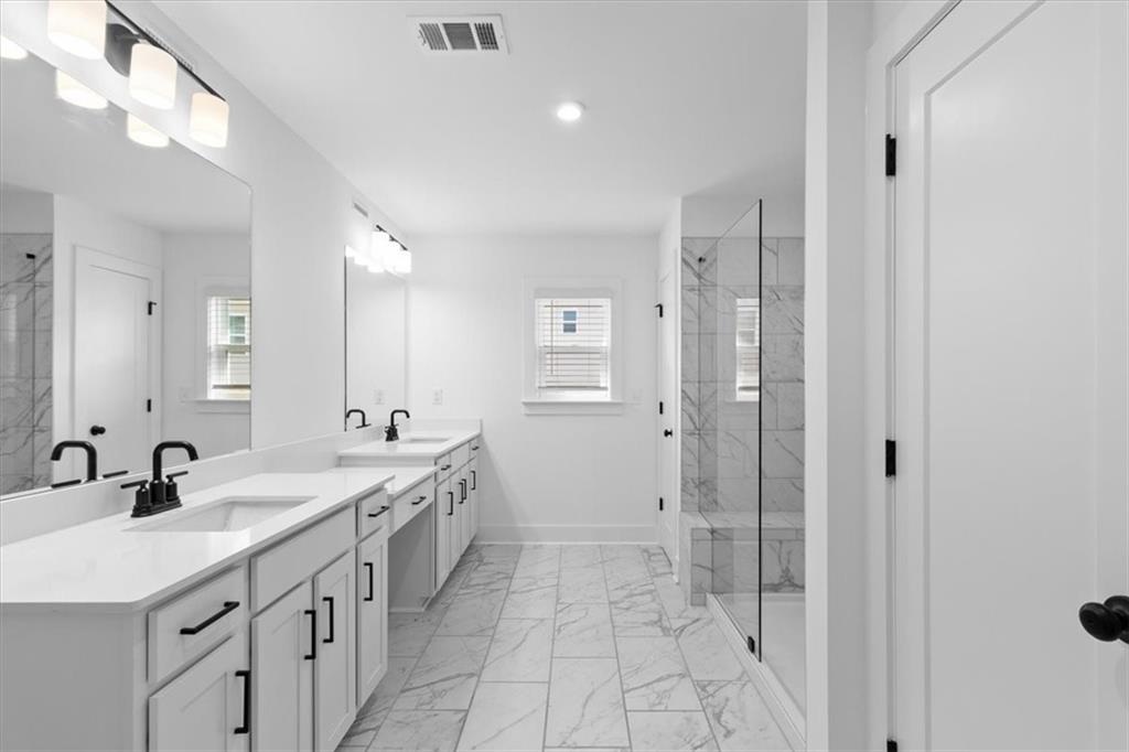 3376 Macaiva Alley Avondale Estates, GA 30002 - Photo 20 of 42 a spacious bathroom with a granite countertop sink mirror and shower
