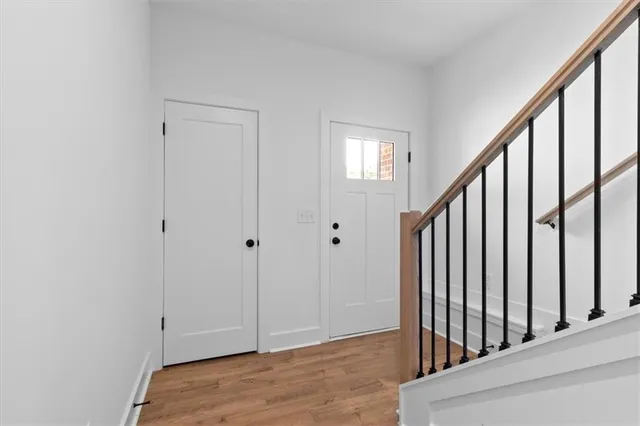 a view of a hallway with wooden floor and entryway