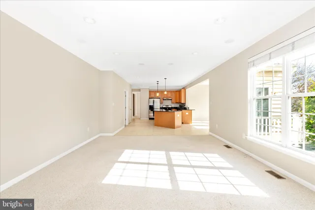 a view of an empty room with closet and a bathroom