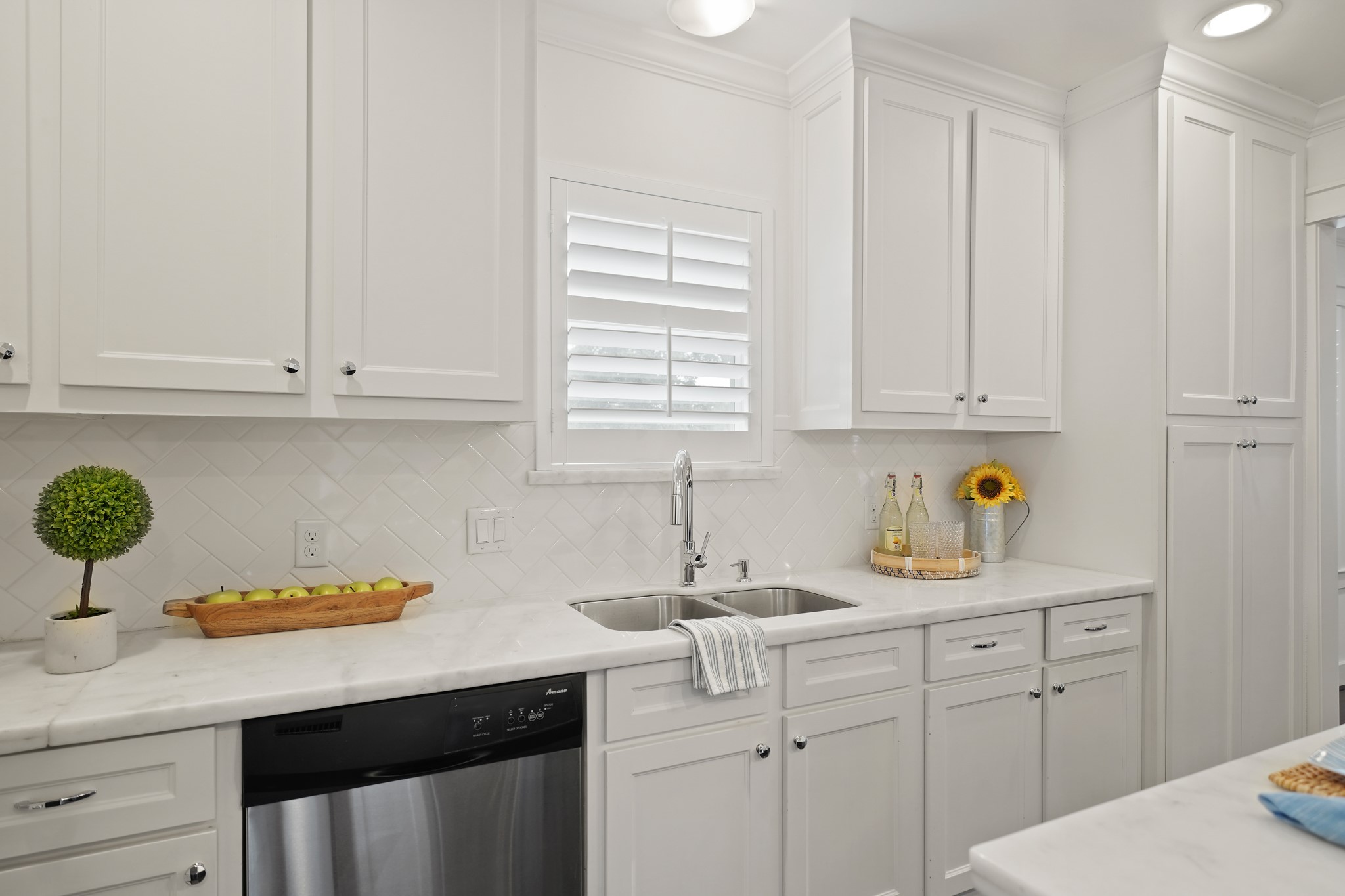 1311 Walton Street Houston, TX 77009 - Photo 16 of 43 The dual basin stainless-steel sink sits below a plantation shuttered window that brings in natural light while additional recessed lighting keeps the space bright and easy to work in.