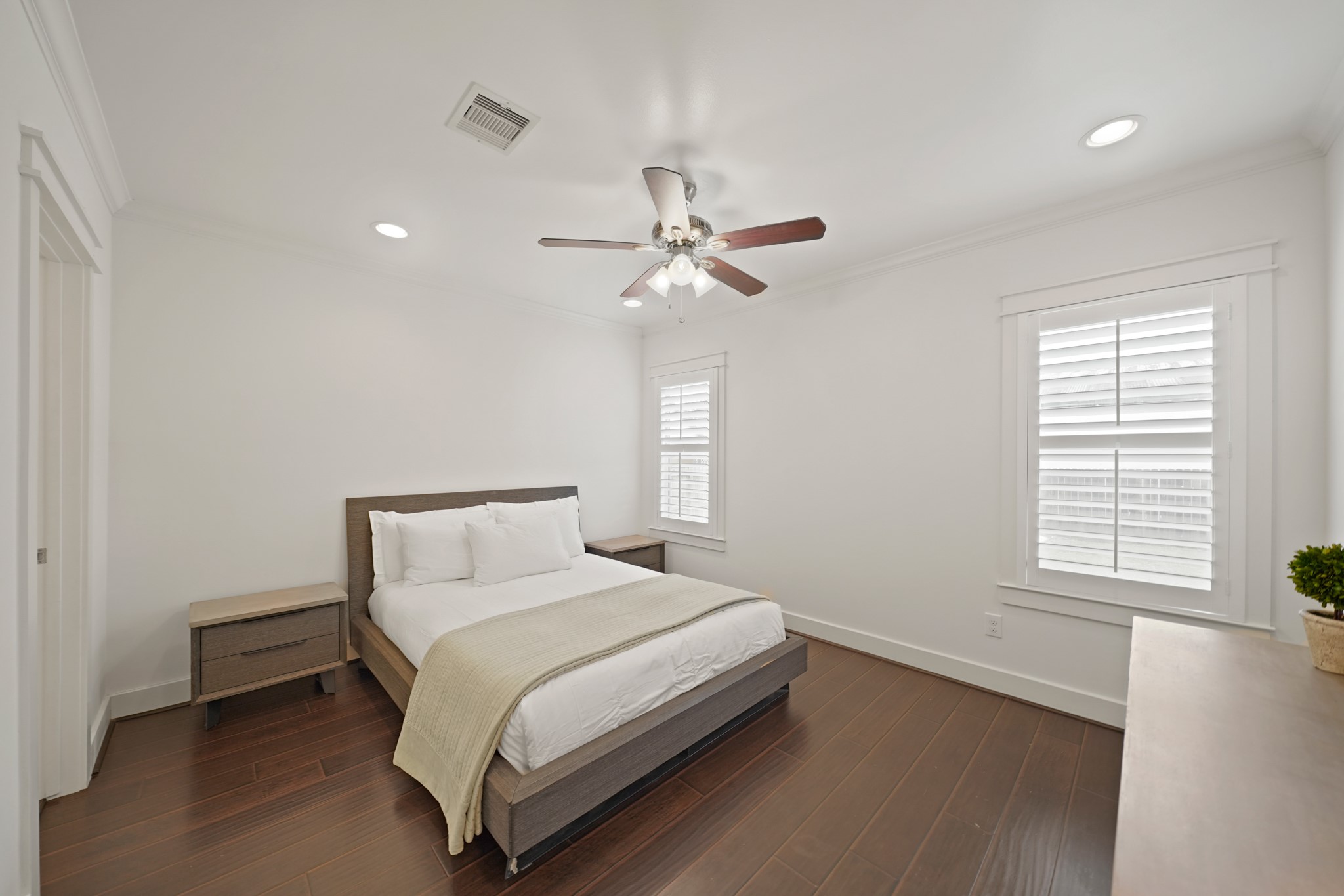 1311 Walton Street Houston, TX 77009 - Photo 19 of 43 The primary bedroom offers a peaceful retreat with beautiful hardwood flooring and crown moulding that brings in a classic touch.