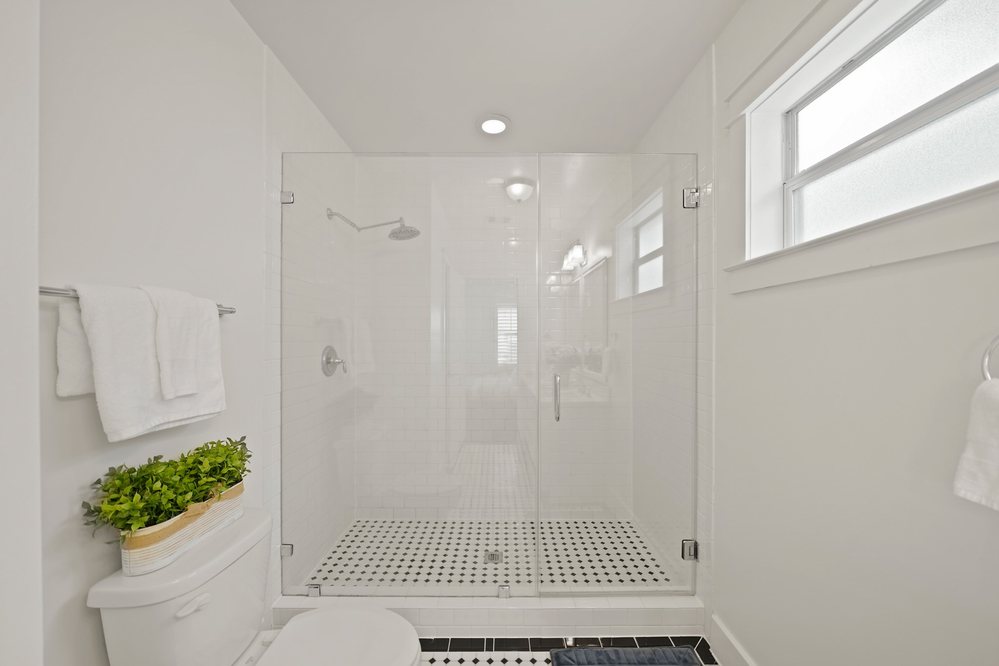 1311 Walton Street Houston, TX 77009 - Photo 23 of 43 A frameless glass shower with floor-to-ceiling subway tile and a brand new oversized shower head and fixtures creates a spa-like experience you’ll enjoy every day.