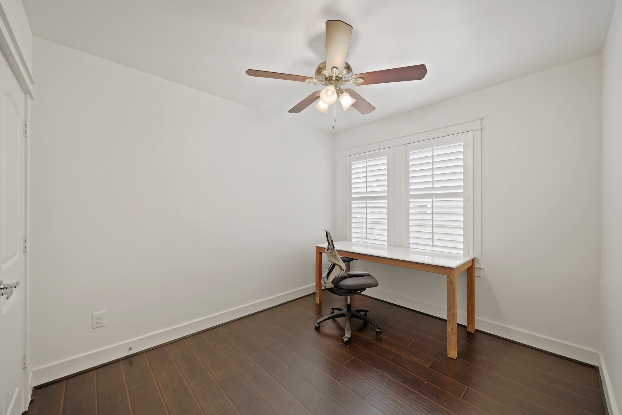1311 Walton Street Houston, TX 77009 - Photo 25 of 43 The second bedroom features hardwood flooring and twin windows with plantation shutters.