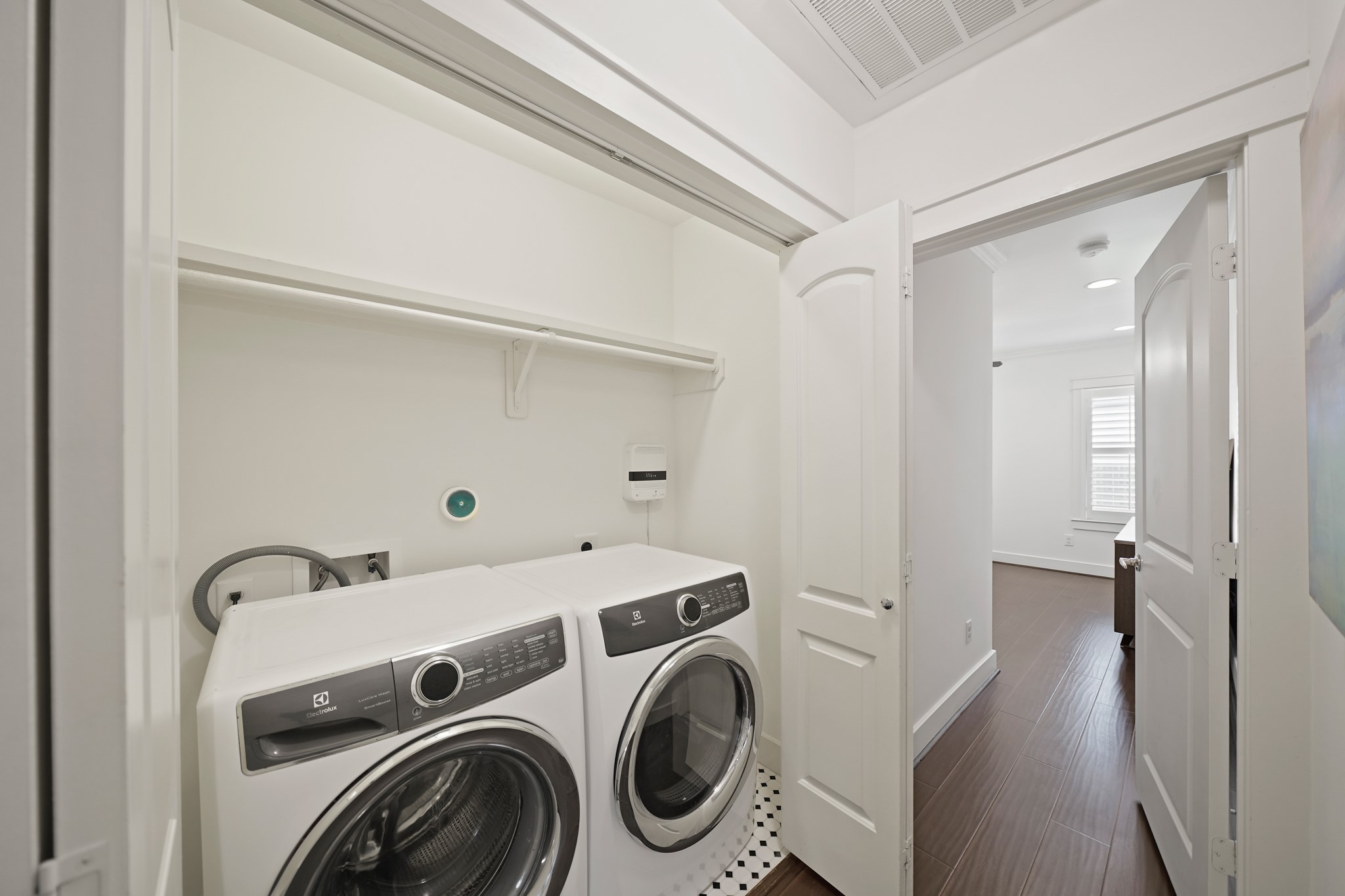 1311 Walton Street Houston, TX 77009 - Photo 30 of 43 The utility room includes tile floors and built-in shelving for storage. The Electrolux front-loading washer and gas dryer stay with the home, making this home move-in ready.