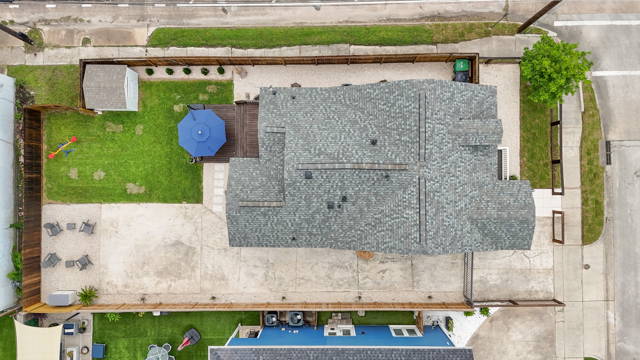 1311 Walton Street Houston, TX 77009 - Photo 31 of 43 A bird’s eye view of the home showcases the lot with the extended, gated driveway, and the overall layout, from the fenced front yard to the tiered back deck and landscaped yard.