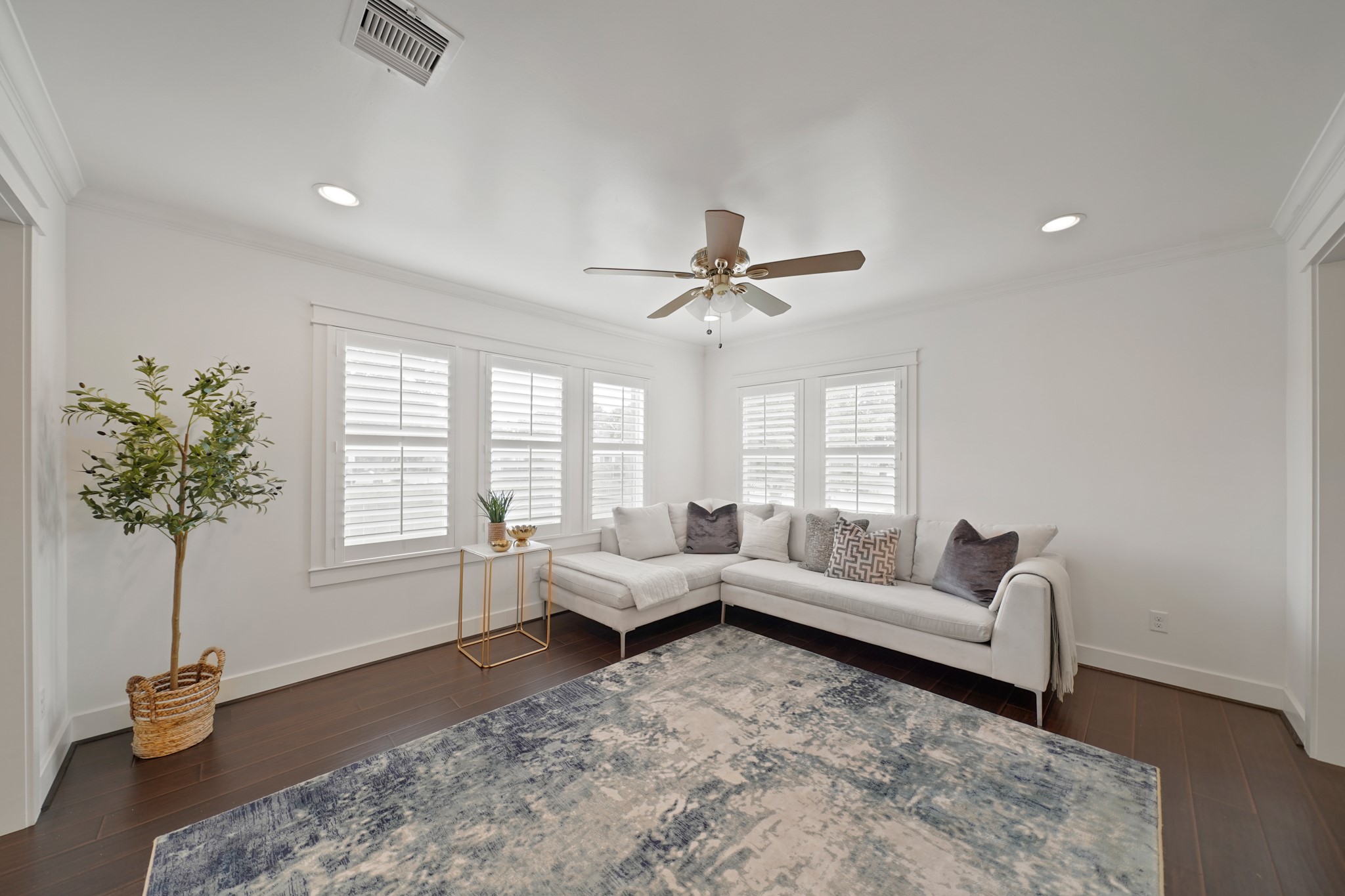 1311 Walton Street Houston, TX 77009 - Photo 8 of 43 Recessed lights, crown moulding, and a ceiling fan with light come together to make this space both stylish and comfortable.