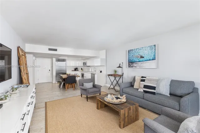 a kitchen with stainless steel appliances granite countertop a table chairs sink and cabinets