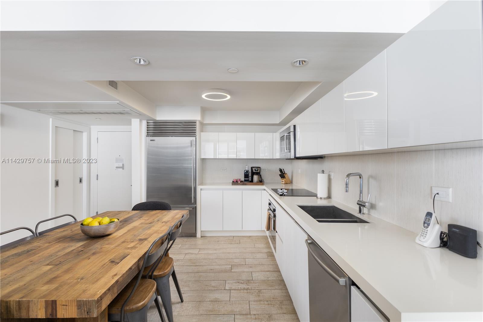 102 24th Street, Unit 1013 Miami Beach, FL 33139 - Photo 26 of 38 a kitchen with a sink a stove and chairs