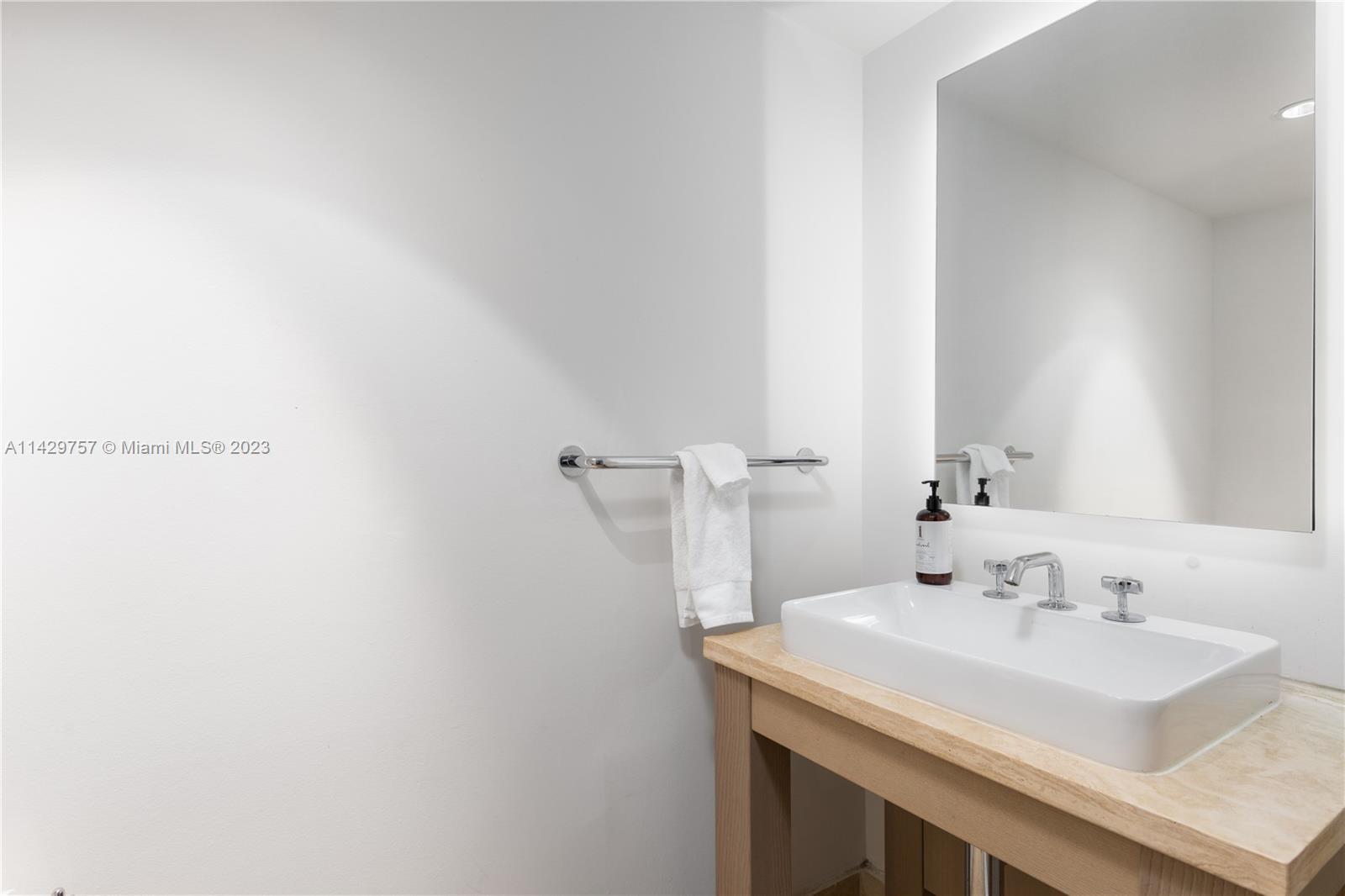 102 24th Street, Unit 1013 Miami Beach, FL 33139 - Photo 28 of 38 a bathroom with a sink and a mirror