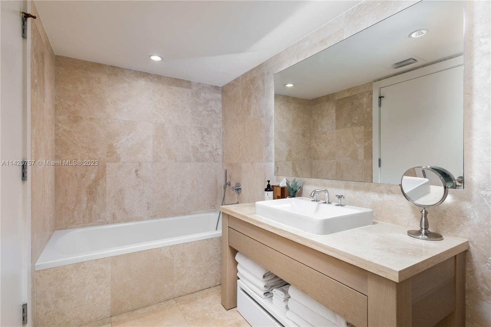 102 24th Street, Unit 1013 Miami Beach, FL 33139 - Photo 32 of 38 a bathroom with a sink and a mirror